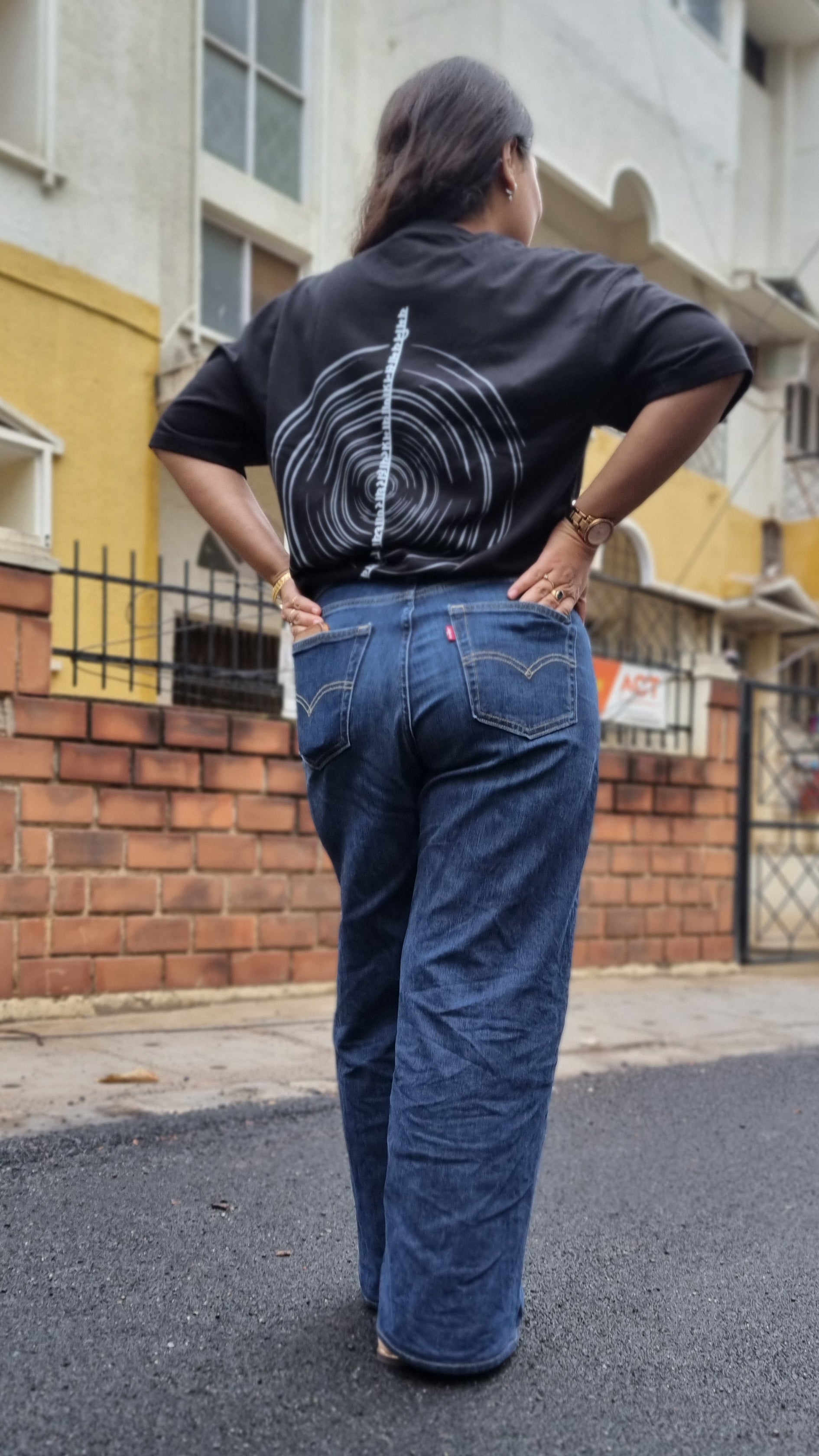 The Ashtanga Yoga T-shirt in Raven Black, worn outdoors, complete head-to-feet back view