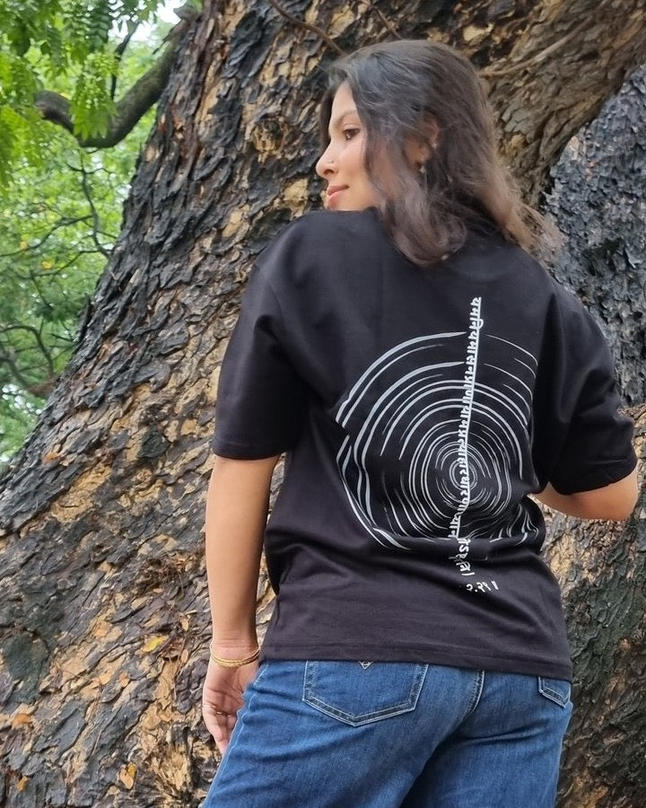 The Ashtanga Yoga T-shirt in Raven Black, worn outdoors, tightly cropped back view