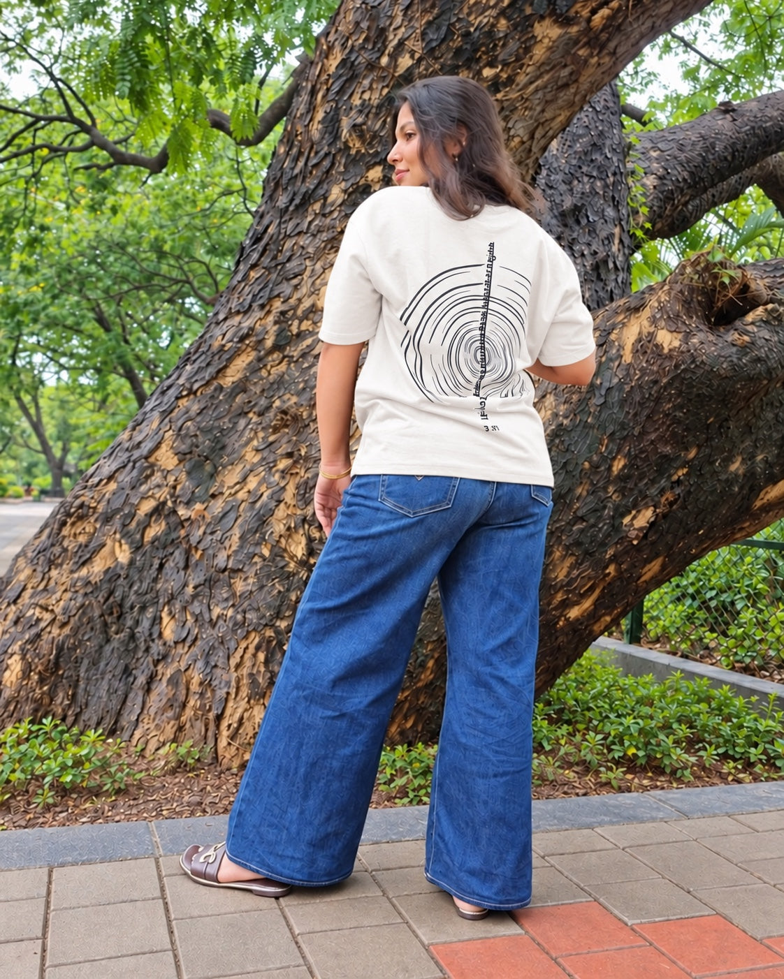 The Ashtanga Yoga T-shirt in Chalk White, worn outdoors, full-length back view