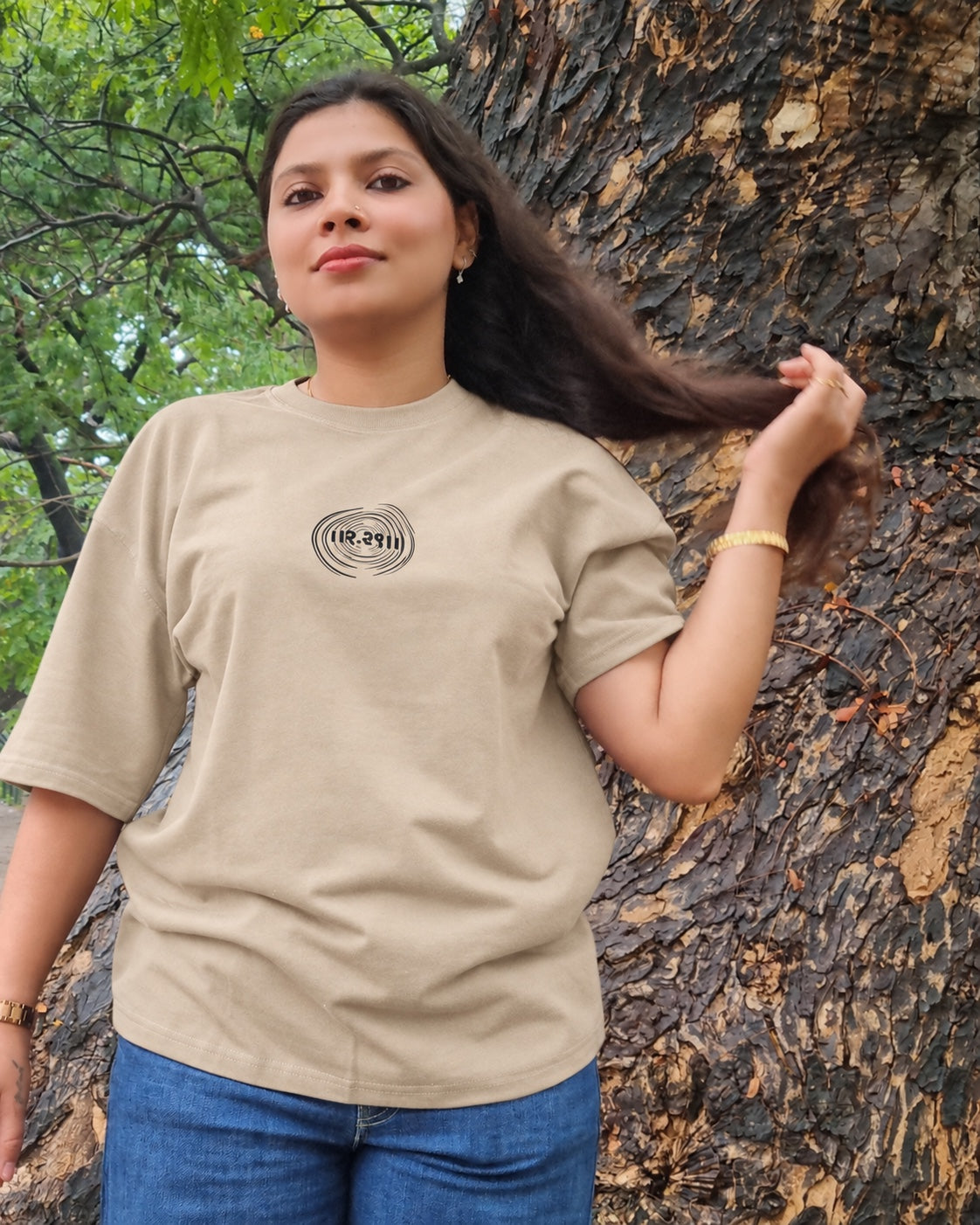 The Ashtanga Yoga T-shirt in Sandy Beige, worn outdoors, close front view